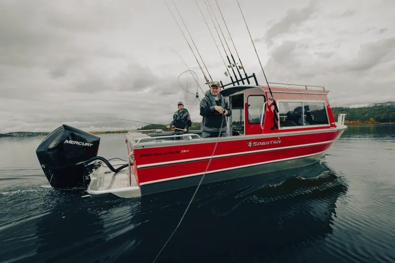 Slide: The Image of 2024 Spartan 240 Maximus Pro boat on water with fishing gear and two people onboard. - 3