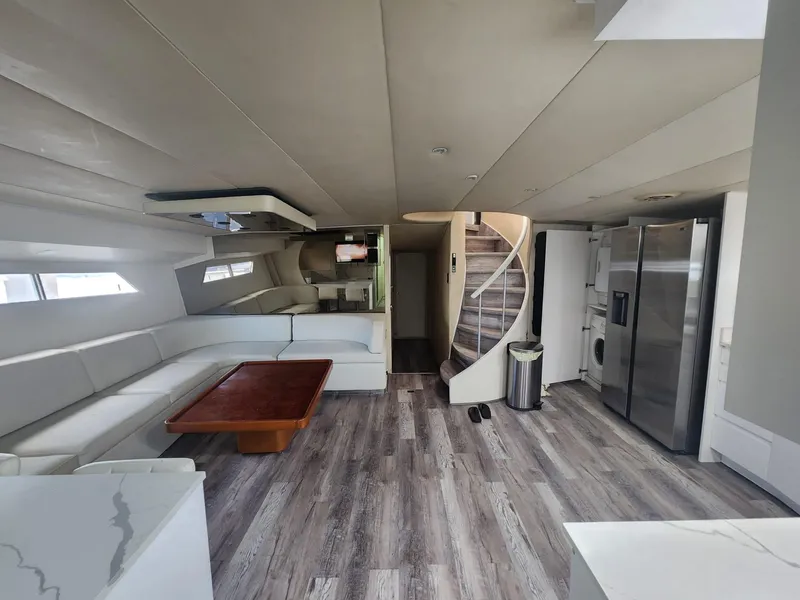 Slide: The Image of Modern interior of 1984 Infinity Express yacht with white seating, wooden table, and spiral staircase. - 16