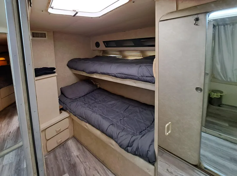 Slide: The Image of 1984 Infinity Express RV interior with bunk beds and storage drawers. - 20