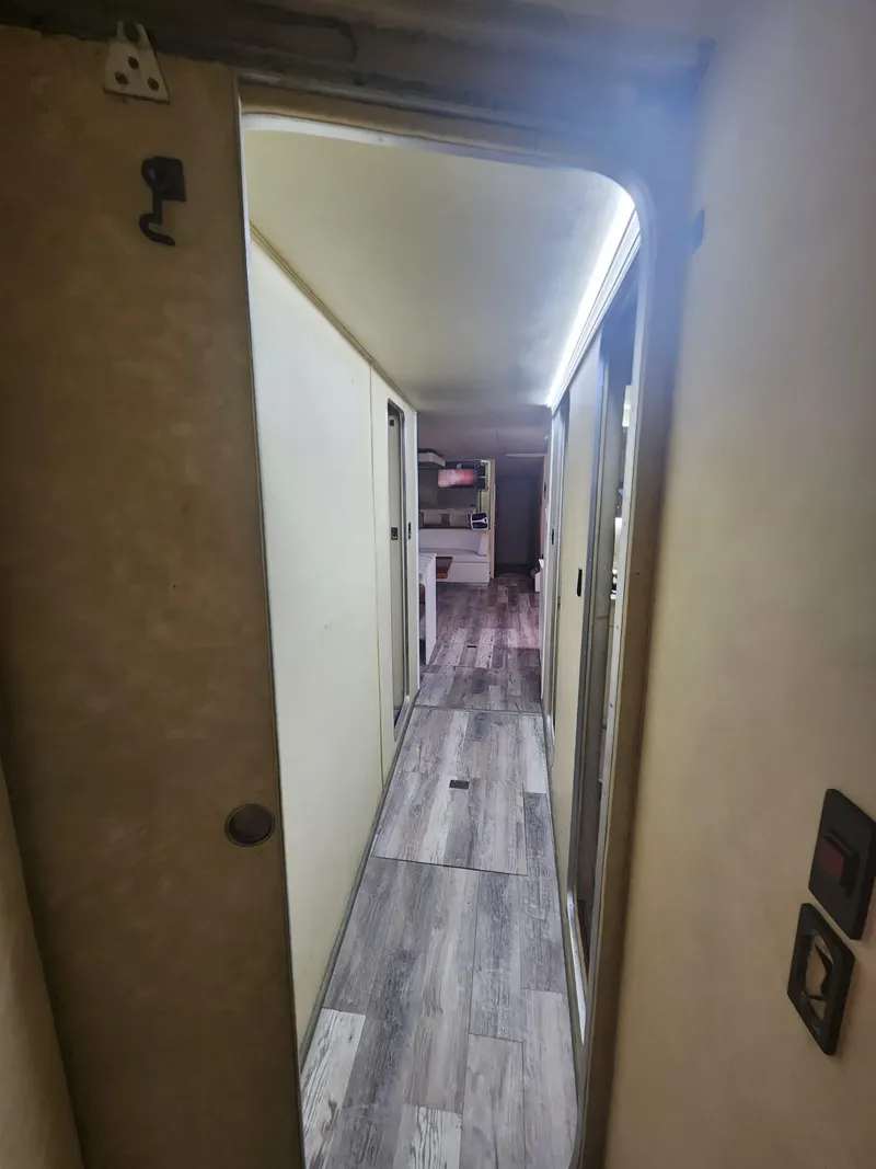 Slide: The Image of 1984 Infinity Express RV interior hallway with wood flooring and beige walls. - 22