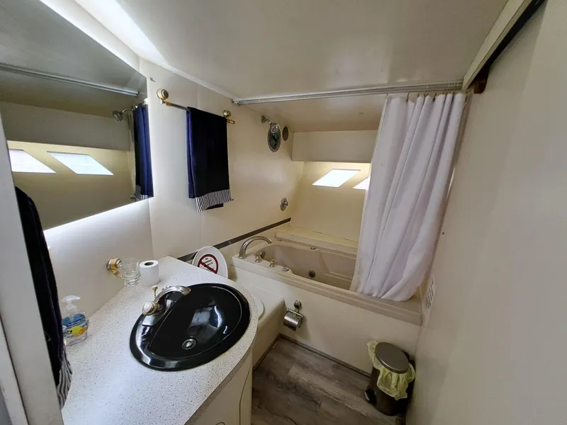 Slide: The Image of 1984 Infinity Express bathroom with black sink, bathtub, and white curtains. - 25