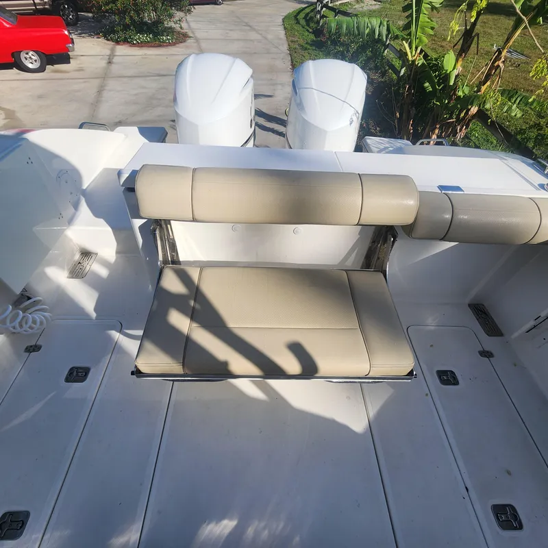 Slide: The Image of 2020 Pursuit OS 325 Offshore boat with beige seating and twin outboard engines. - 15