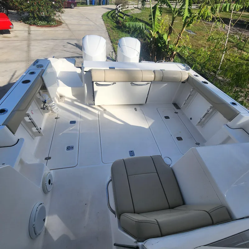 Slide: The Image of 2020 Pursuit OS 325 Offshore boat deck with seating and twin outboard engines. - 16