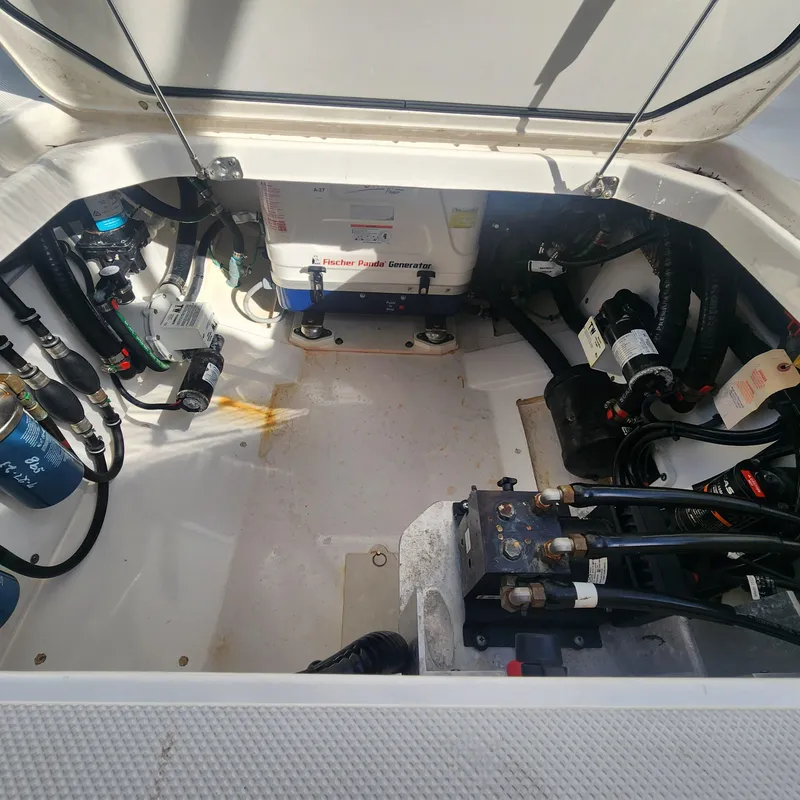 Slide: The Image of Engine compartment of a 2020 Pursuit OS 325 Offshore boat showing various mechanical components. - 19