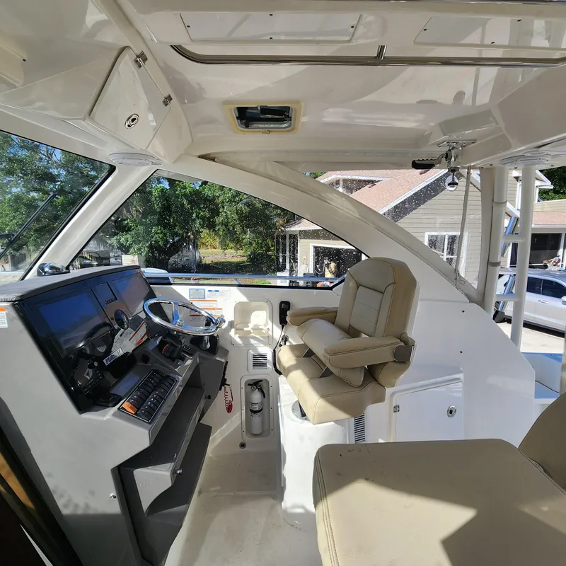 Slide: The Image of Interior helm of a 2020 Pursuit OS 325 Offshore boat with captain's chair and control panel. - 22