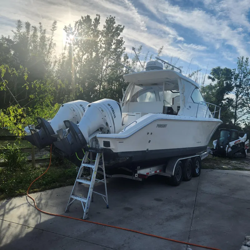 Slide: The Image of 2020 Pursuit OS 325 Offshore boat on trailer with twin outboard engines. - 3