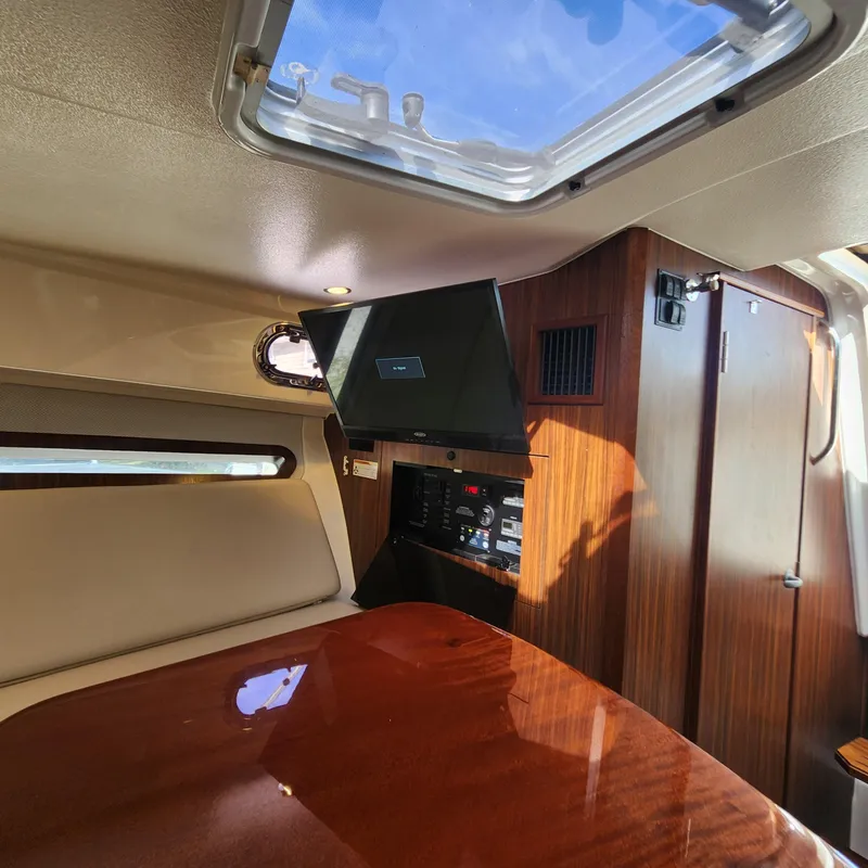Slide: The Image of Interior cabin of 2020 Pursuit OS 325 Offshore boat with TV and wooden finishes. - 31