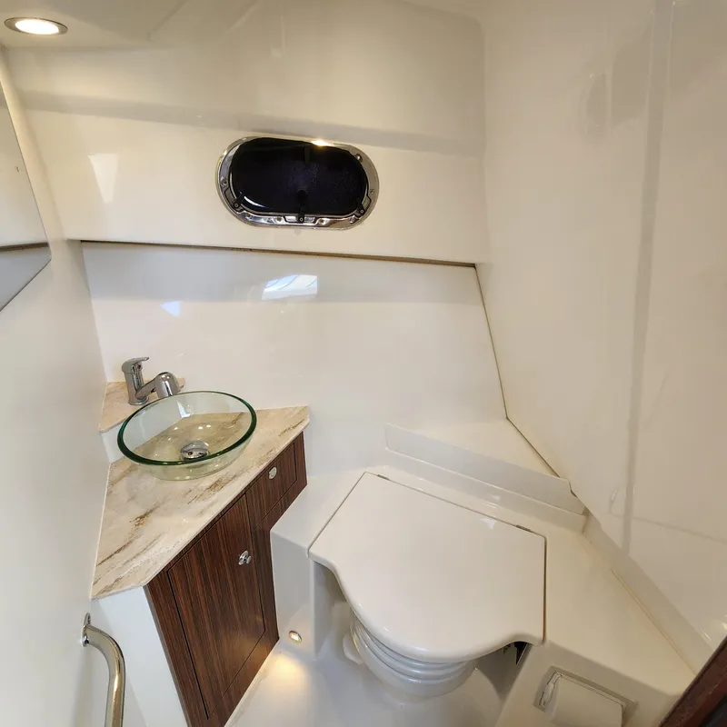 Slide: The Image of 2020 Pursuit OS 325 Offshore boat bathroom with modern sink and toilet. - 33
