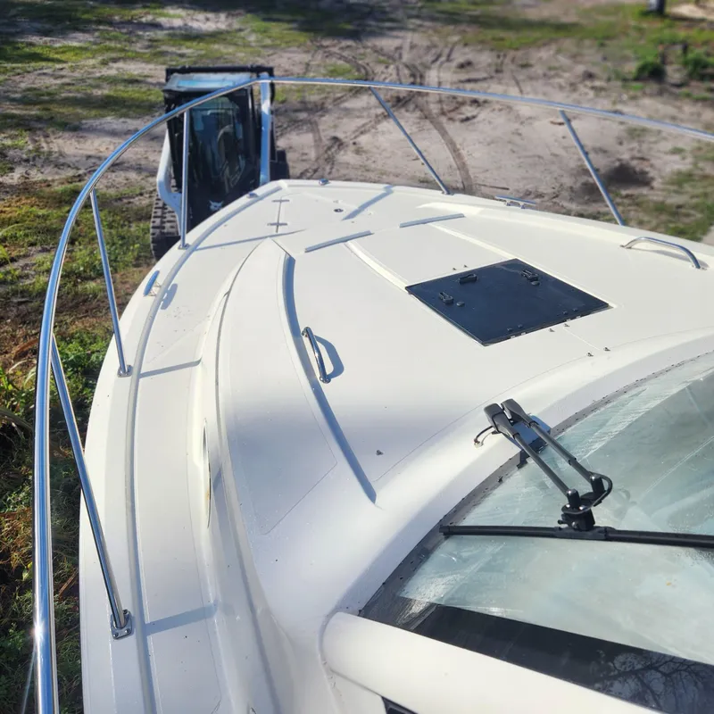 Slide: The Image of 2020 Pursuit OS 325 Offshore boat on land, front view with railing and hatch. - 6