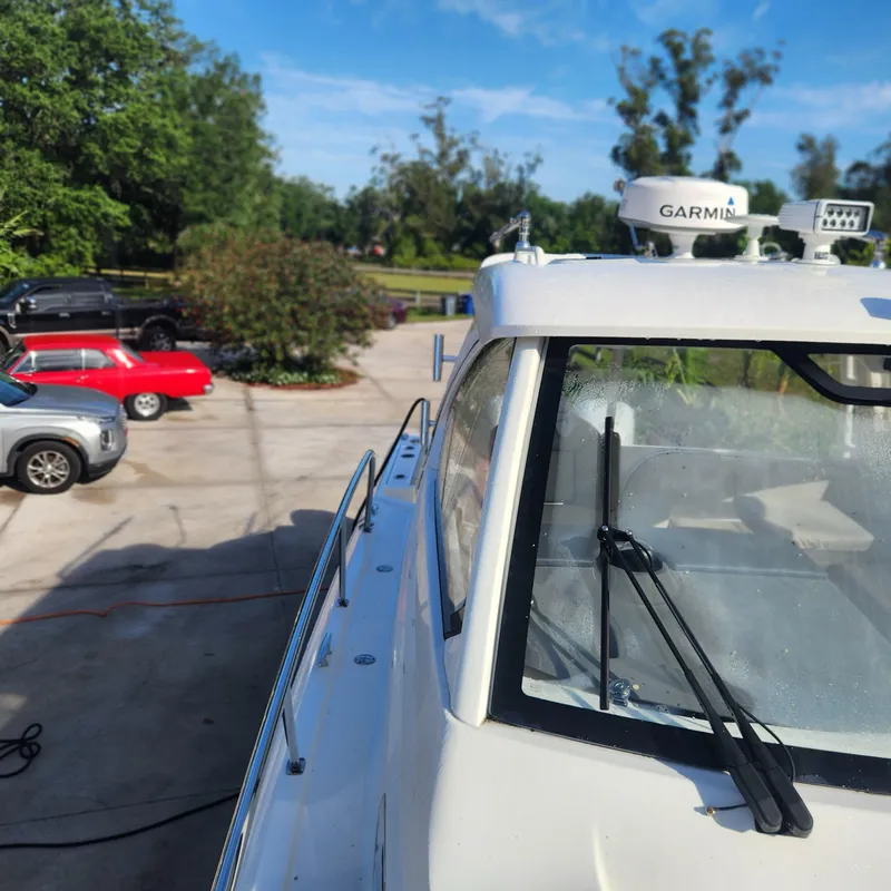 Slide: The Image of 2020 Pursuit OS 325 Offshore boat with Garmin equipment in a driveway. - 8