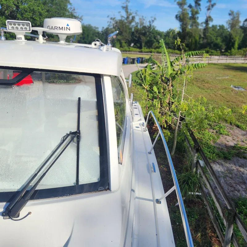 Slide: The Image of 2020 Pursuit OS 325 Offshore boat with Garmin radar, docked near greenery. - 9