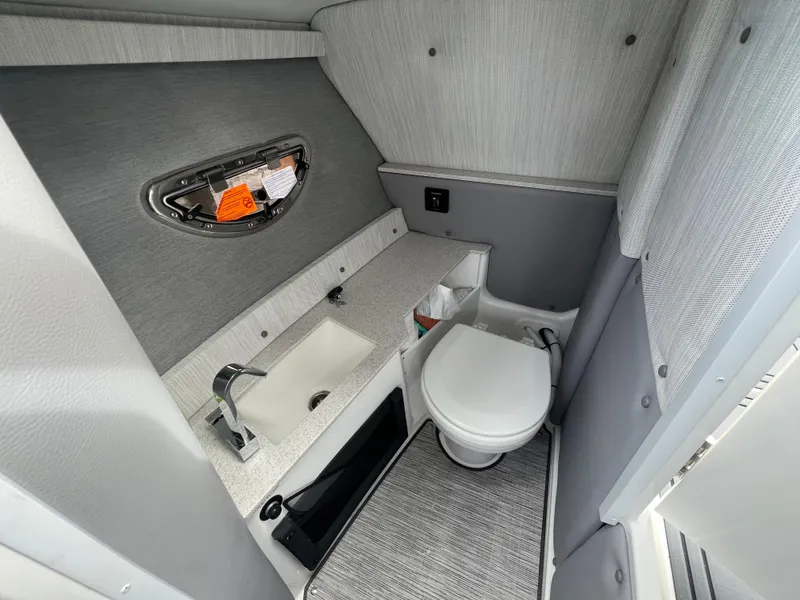 Slide: The Image of 2024 Cobalt R6 Surf boat interior bathroom with sink and toilet, modern design. - 16