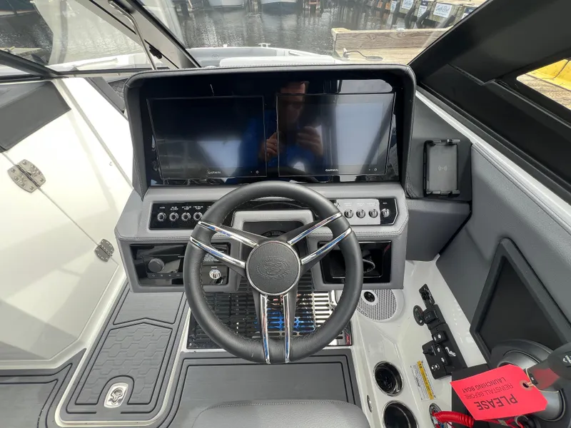 Slide: The Image of 2024 Cobalt R6 Surf boat dashboard with steering wheel and dual Garmin displays. - 18