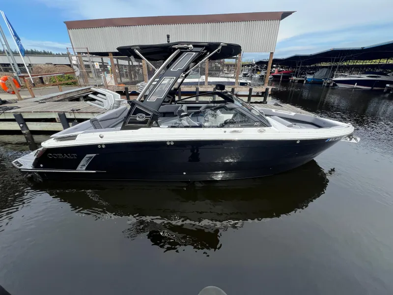 Slide: The Image of 2024 Cobalt R6 Surf boat docked at marina, side view. - 4