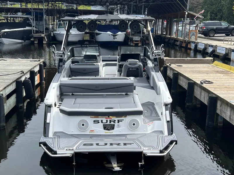 Slide: The Image of 2024 Cobalt R6 Surf boat docked at marina, rear view. - 6