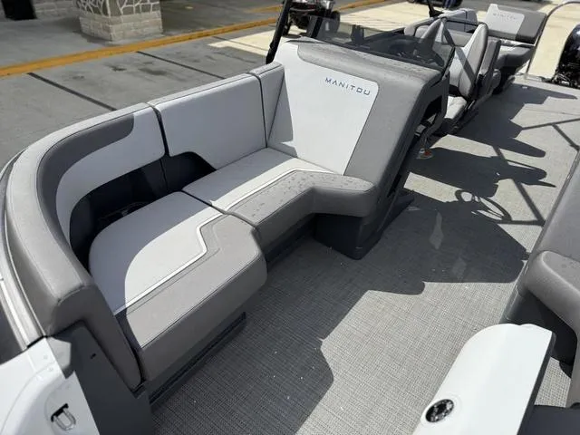 Slide: The Image of 2024 Manitou Cruise 22 Max Switchback V-Toon with sleek gray seating and modern design. - 13
