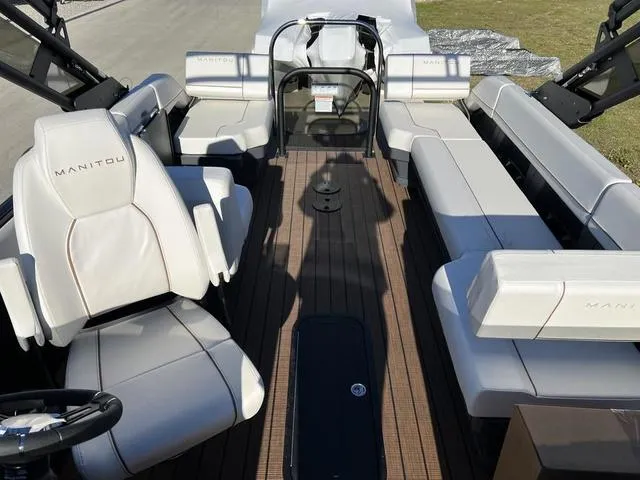 Slide: The Image of 2024 Manitou Explore 26 Switchback Single Engine V-Toon interior with white seating and wood flooring. - 13
