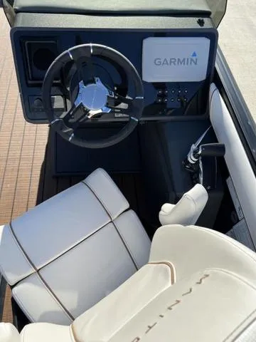 Slide: The Image of 2024 Manitou Explore 26 Switchback Single Engine V-Toon boat cockpit with Garmin navigation system. - 14