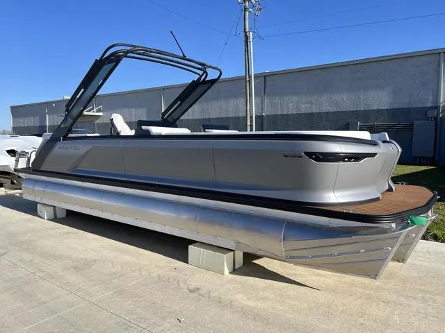 Slide: The Image of 2024 Manitou Explore 26 Switchback Single Engine V-Toon pontoon boat in a parking lot. - 3