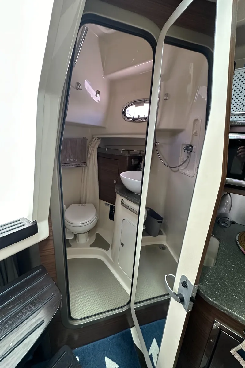 Slide: The Image of 2015 Boston Whaler 345 Conquest bathroom interior with toilet, sink, and shower. - 11