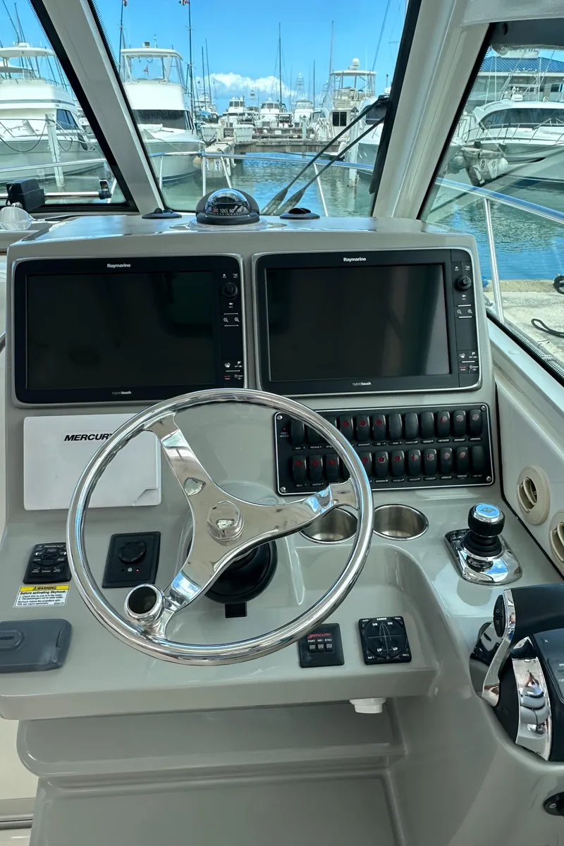 Slide: The Image of 2015 Boston Whaler 345 Conquest helm with dual screens and steering wheel. - 3