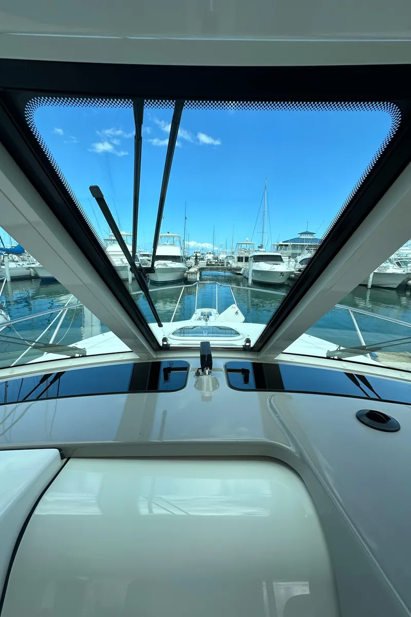 Slide: The Image of 2015 Boston Whaler 345 Conquest view from helm, overlooking marina with boats. - 7