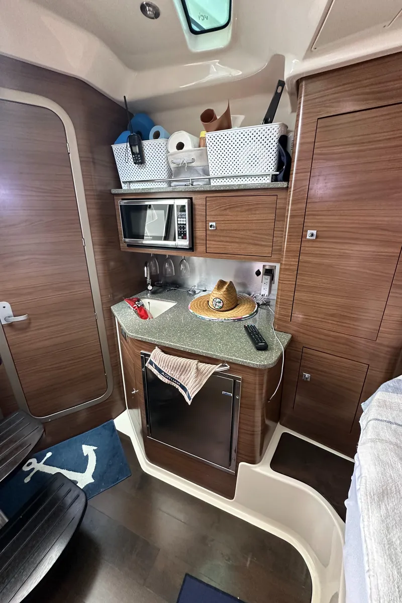 Slide: The Image of 2015 Boston Whaler 345 Conquest cabin with kitchenette, microwave, and storage baskets. - 9