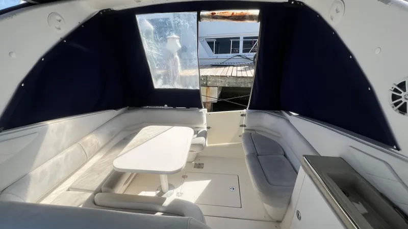 Slide: The Image of 2003 Regal Commodore 3260 interior with seating and table, featuring blue curtains. - 17