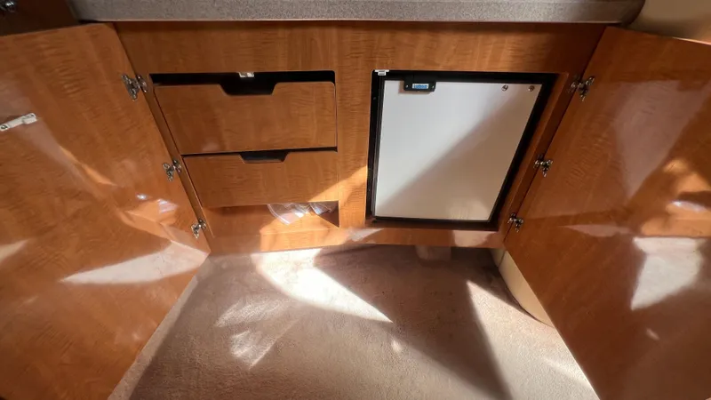 Slide: The Image of 2003 Regal Commodore 3260 interior with wooden cabinets and mini fridge. - 22