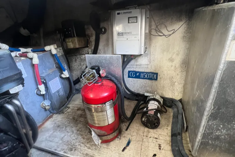 Slide: The Image of 2003 Regal Commodore 3260 engine room with fire extinguisher and electrical panel. - 38