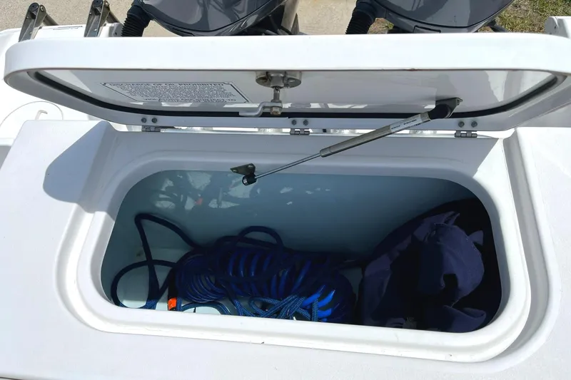 Slide: The Image of Open storage compartment on a 2012 Sea Hunt Gamefish 25 boat with blue rope inside. - 18
