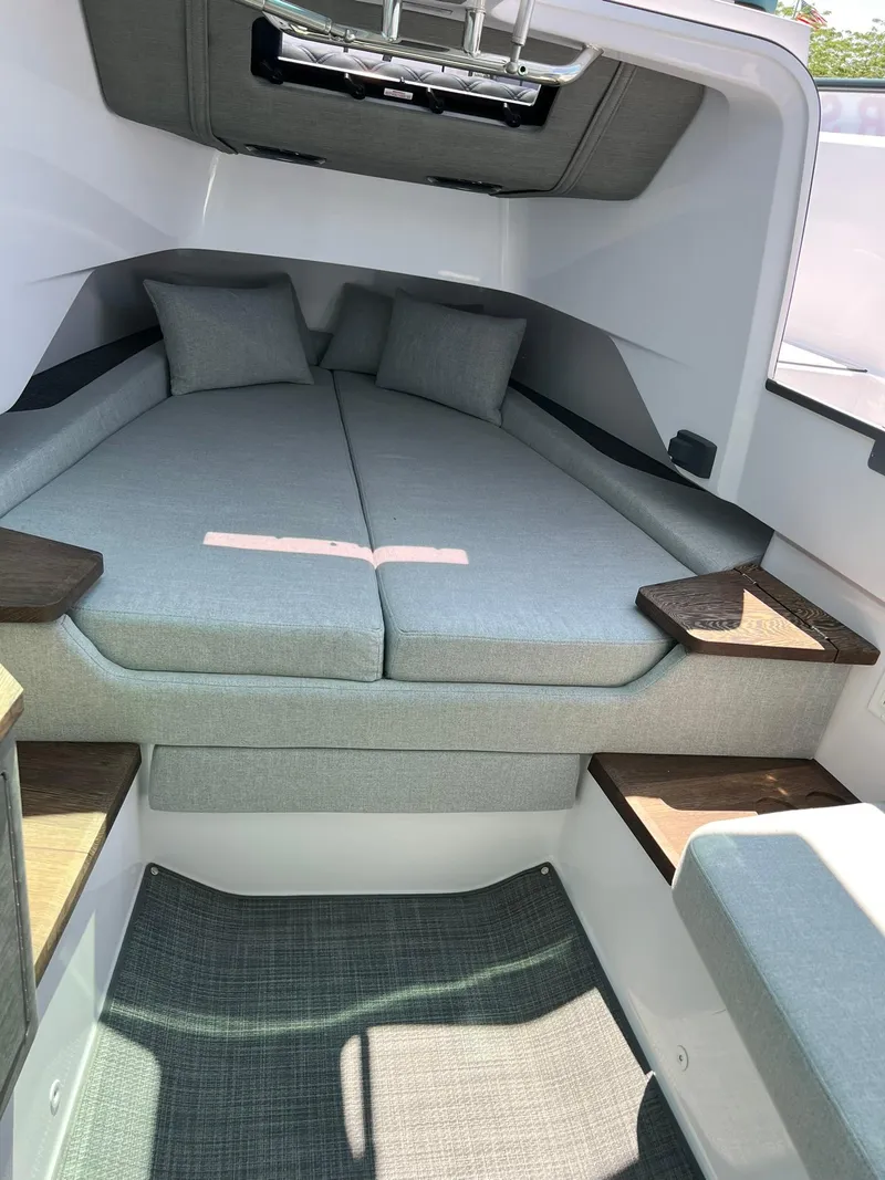 Slide: The Image of 2022 Axopar 37 Sun Top cabin interior with cushioned bed and wooden accents. - 22