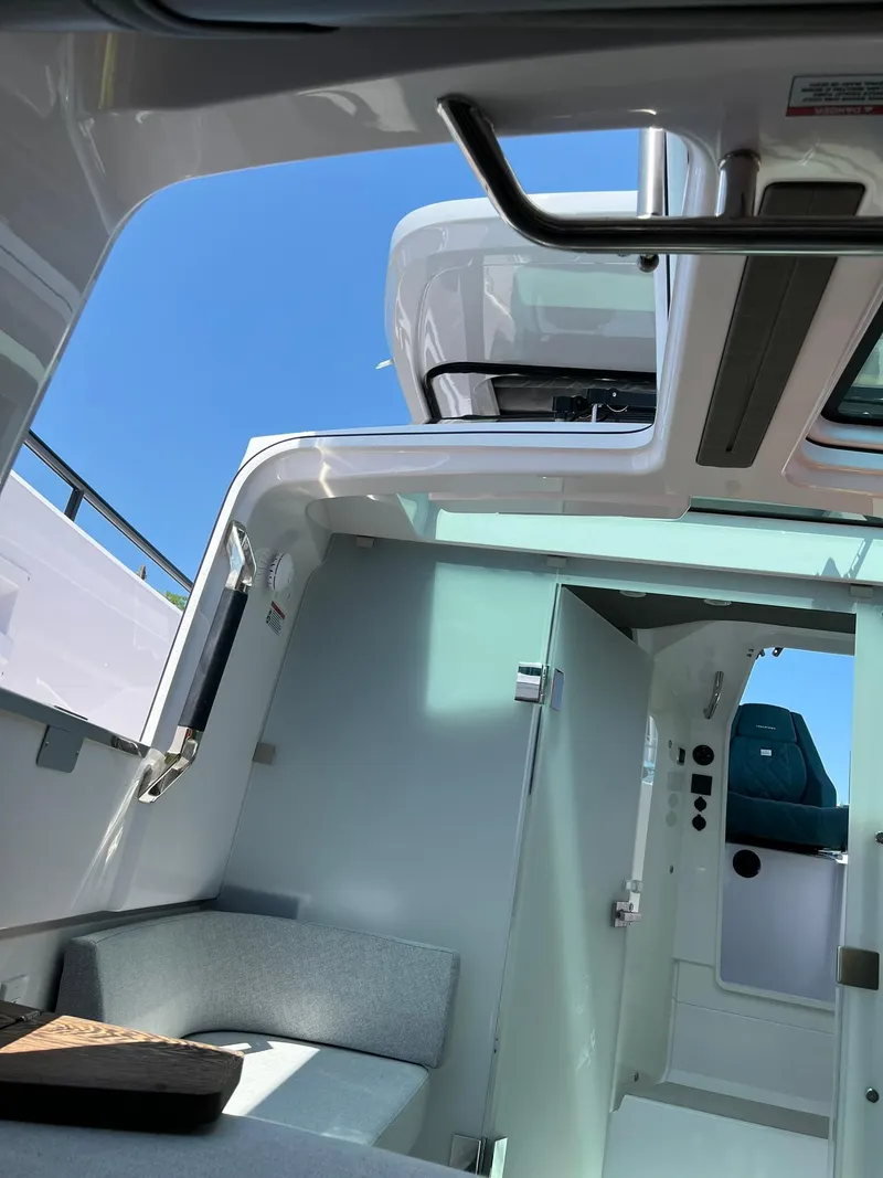 Slide: The Image of Interior view of 2022 Axopar 37 Sun Top boat with open roof and seating area. - 25