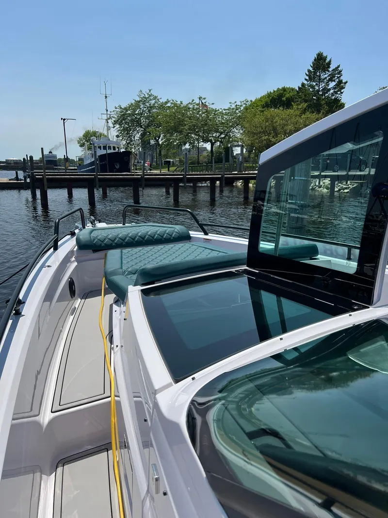Slide: The Image of 2022 Axopar 37 Sun Top boat docked at a marina on a sunny day. - 26