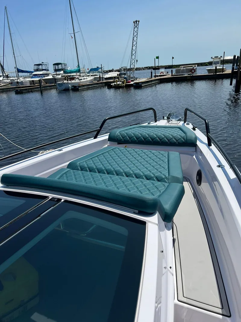 Slide: The Image of 2022 Axopar 37 Sun Top boat with teal seating at a marina. - 30