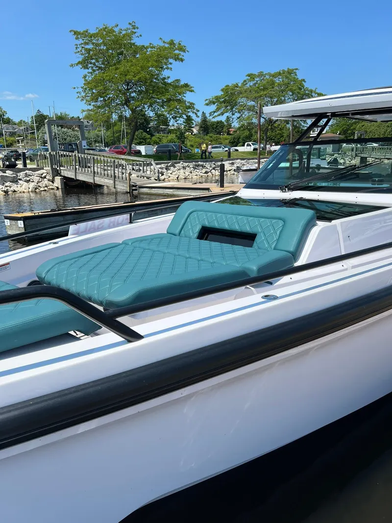 Slide: The Image of 2022 Axopar 37 Sun Top boat with teal seating docked at a marina. - 31