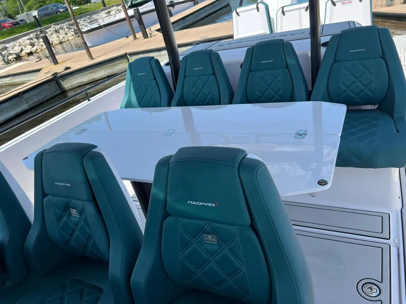 Slide: The Image of 2022 Axopar 37 Sun Top boat with teal seating and white table. - 32