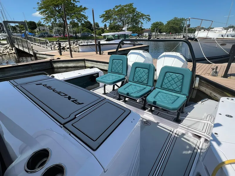 Slide: The Image of 2022 Axopar 37 Sun Top boat with teal seats docked at a marina. - 34