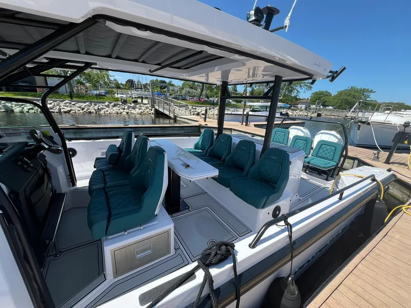 Slide: The Image of 2022 Axopar 37 Sun Top boat with teal seating docked at marina. - 36