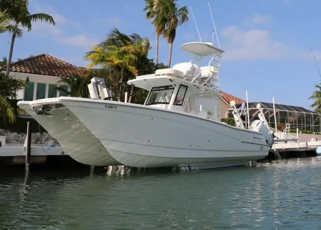 Slide: The Image of 2022 World Cat 400CC-X boat docked near tropical palm trees. - 3