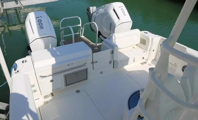 Slide: The Image of World Cat 400 CC-X 2022 boat interior on calm water, showcasing seating and deck layout. - 30