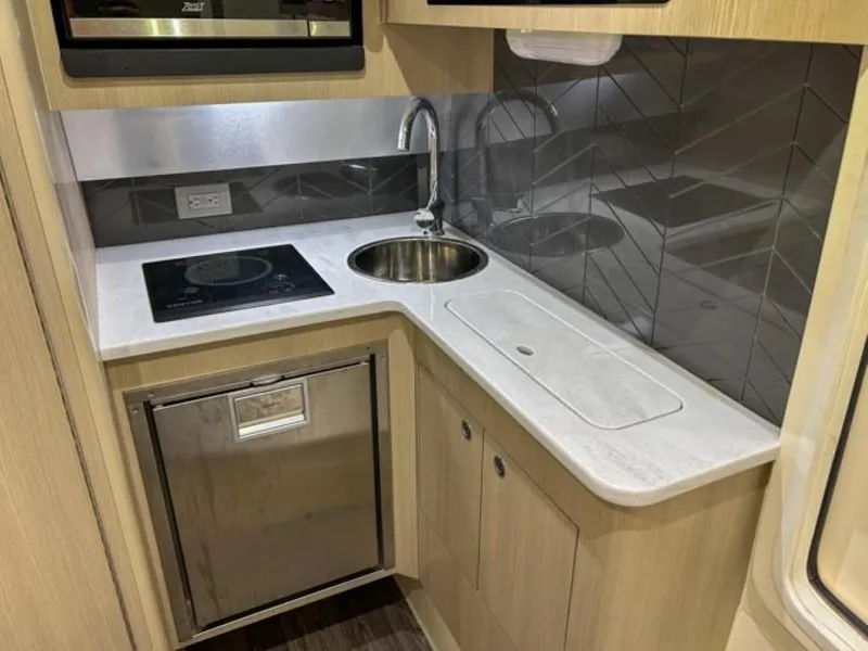 Slide: The Image of 2023 Scout 400 LXF boat kitchen with modern appliances and sleek design. - 18
