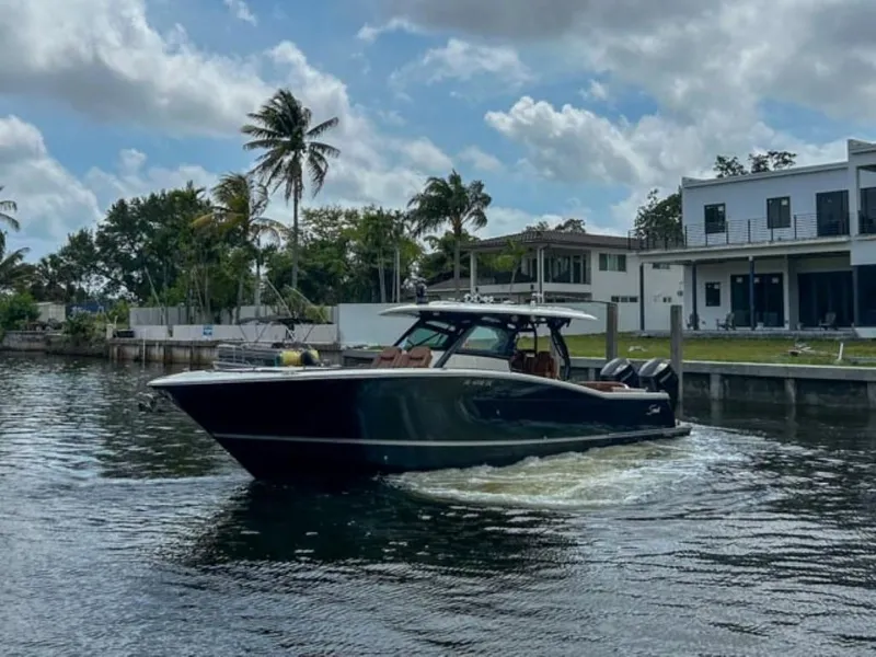 Slide: The Image of 2023 Scout 400 LXF boat cruising in a residential canal. - 4
