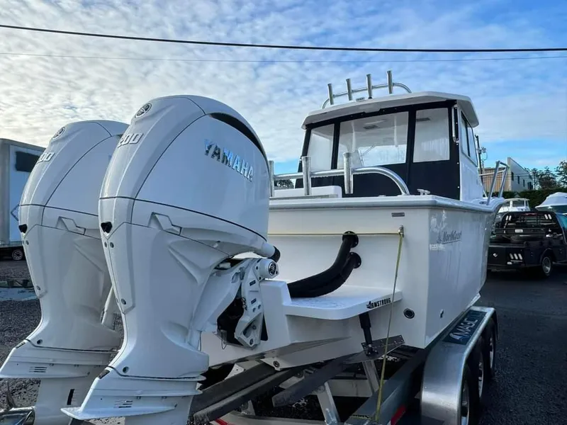 Slide: The Image of 2024 NorthCoast 255 Cabin boat with twin Yamaha engines on a trailer. - 12
