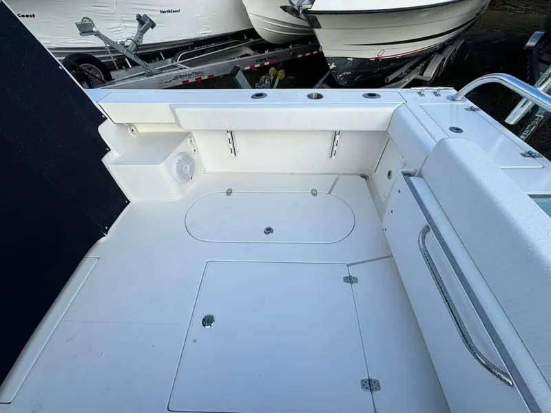 Slide: The Image of 2024 NorthCoast 255 Cabin boat deck with storage compartments and seating. - 19