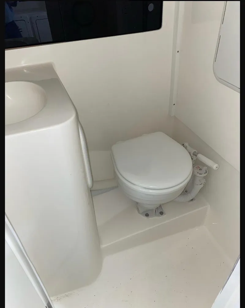 Slide: The Image of 2024 NorthCoast 255 Cabin boat bathroom with toilet and sink. - 26