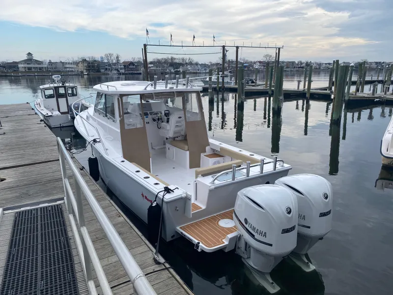 Slide: The Image of 2024 NorthCoast 255 Cabin boat docked with twin Yamaha engines. - 29
