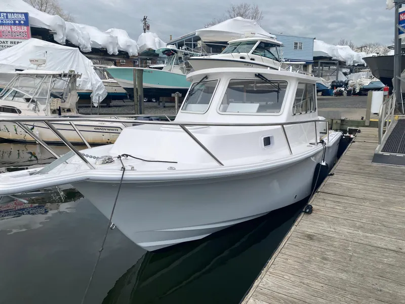 Slide: The Image of 2024 NorthCoast 255 Cabin boat docked at a marina. - 30