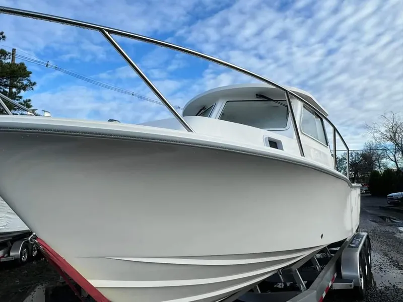Slide: The Image of 2024 NorthCoast 255 Cabin boat on trailer under a blue sky. - 5