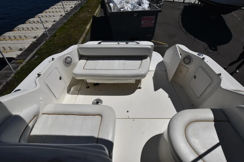 Slide: The Image of 1998 Sea Ray 270 Sundancer boat interior with white seating and dockside view. - 7